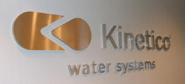 Teksten Kinetco water systems udført i børstet stål, stag og coronabelysning
