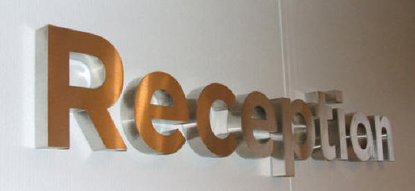 Teksten Kinetco water systems udført i børstet stål, stag og coronabelysning