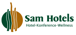 Sam Hotels� vartegn er de 3 tr�skulpturer, tegnet og udf�rt af Palle Lindau. De 3 tr�skulpturer er d�bt S-a-m og udg�r i ny form hotellets logo.
