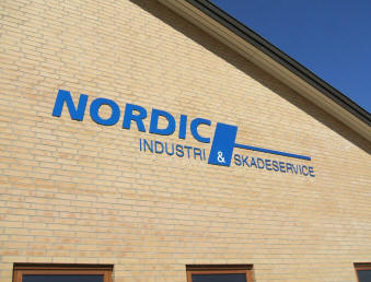 Udsk�rne logoer og tekster i alle materiale - her et eksempel p� lasersk�rne aluminiumsbogstaver, monteret p� en r�mur, for Nordic Industri og Skadeservice.